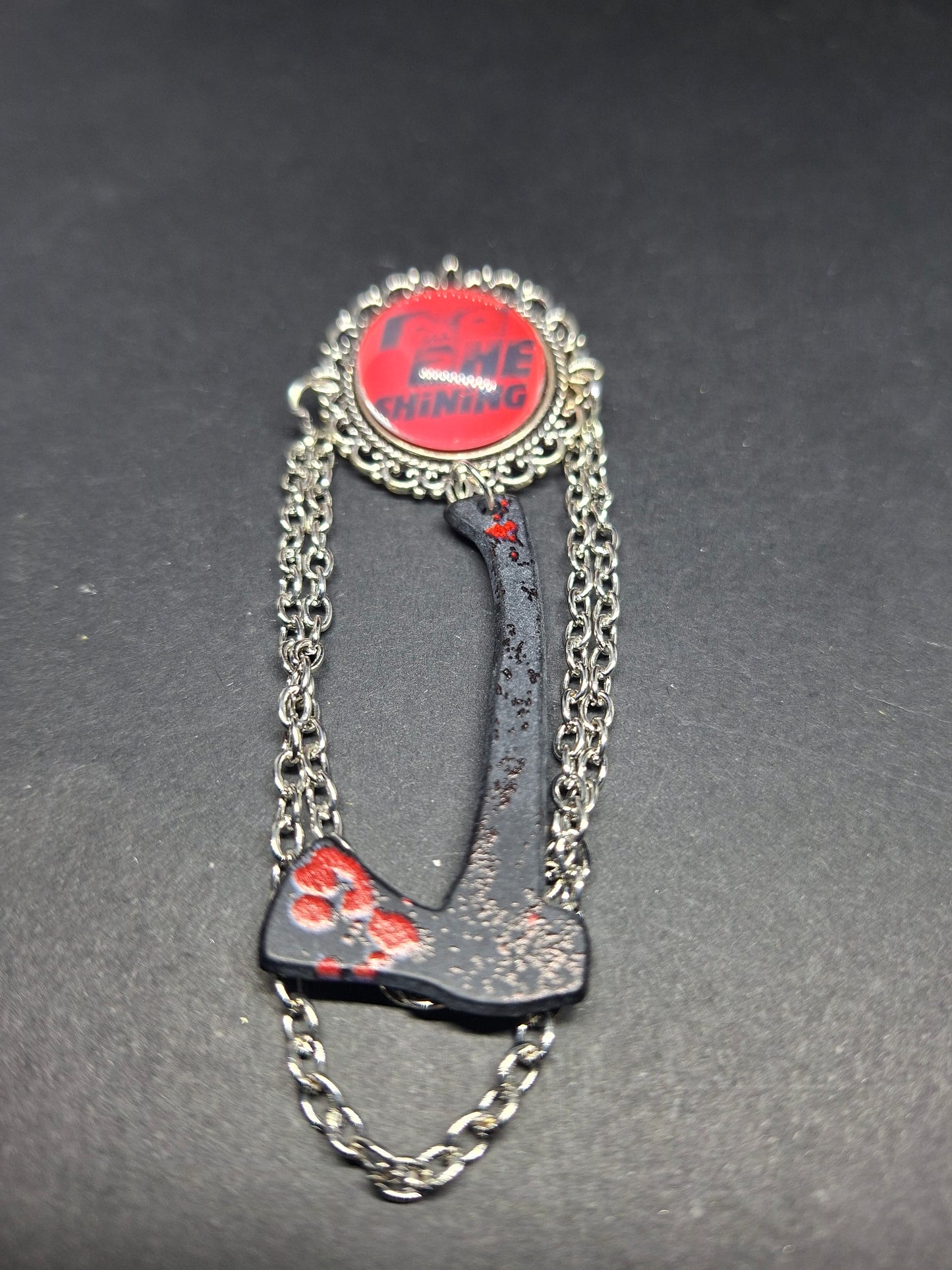 Ornate brooch with chains and blooded axe ,The shining inspired