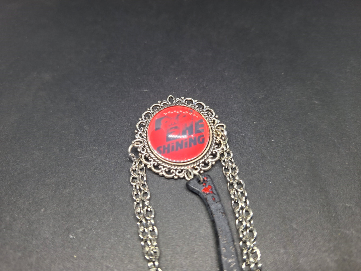 Ornate brooch with chains and blooded axe ,The shining inspired